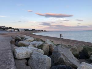 a person sitting on a rock near a body of water at Manor Hotel in Exmouth