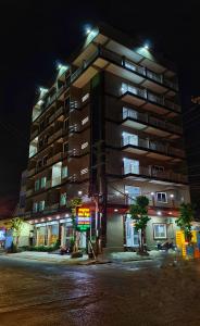 um grande edifício de apartamentos à noite com luzes em Pheng Chenda Hotel em Krong Poi Pet