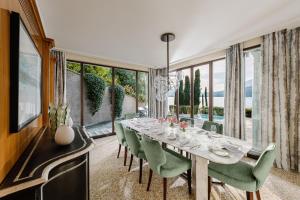 a dining room with a long table and green chairs at Mandarin Oriental, Lago di Como in Blevio