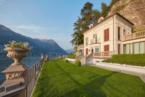 a large house with a yard next to a body of water at Mandarin Oriental, Lago di Como in Blevio
