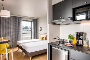a hotel room with a bed and a kitchen at Adagio Access Stuttgart Airport Messe in Leinfelden-Echterdingen