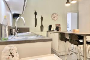 a kitchen with a sink and a counter with chairs at #J0 The sweet Jaurès in Grenoble