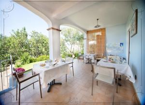 a dining room with white tables and chairs at B&b La Giara in Maratea