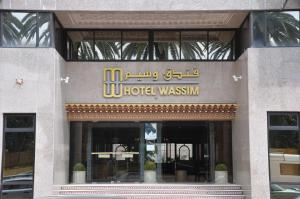 a hotel with a sign on the front of a building at Hôtel Wassim in Fès