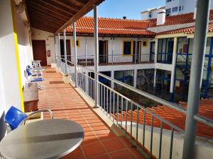 a balcony of a house with a table and chairs at HI Lagos - Pousada de Juventude in Lagos