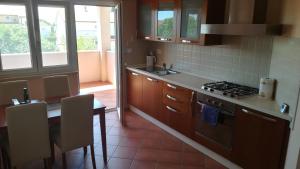 een keuken met een tafel en een fornuis bovenste oven bij Apartment Leonardo in Medulin