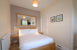 1 dormitorio con cama blanca y espejo en Abbey Guest House York en York