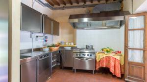 a kitchen with a stove and a table in it at FONTE CANNELLA 12&4, Emma Villas in Manciano