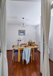 una sala da pranzo con tavolo in legno e sedie blu di Apartments Ranieri Kono a Dubrovnik