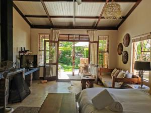 ein Wohnzimmer mit einem Bett, einem Sofa und einem Tisch in der Unterkunft A Hilltop Country Retreat in Swellendam