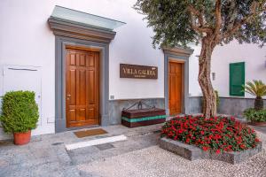 un bâtiment avec un arbre et des fleurs devant un bâtiment dans l'établissement Amore Rentals - Villa Galidia, à Sorrente