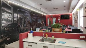 a waiting room with a sink and a red wall at Hotel Oleum in Belchite