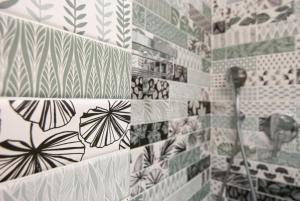 a bathroom with black and white tiles on the wall at MAJOR SISTERS, APPARTAMENTO VISTA LAGO DI LUGANO in Porto Ceresio