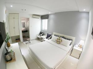 a white bedroom with a large white bed in it at Dinh Phat Hotel in Ho Chi Minh City