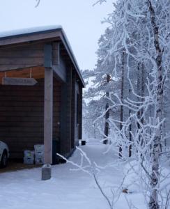 a cabin with snow on the side of it at Arctic Nature Lodge in Inari