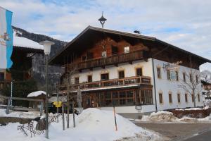 un grande edificio con tetto di gambero nella neve di Rait´ner Wirt a Schleching