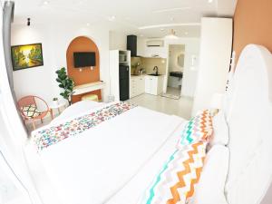 1 dormitorio con 1 cama blanca y cocina en Dinh Phat Hotel, en Ho Chi Minh