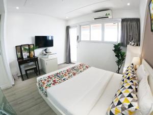 a bedroom with a white bed and a television at Dinh Phat Hotel in Ho Chi Minh City