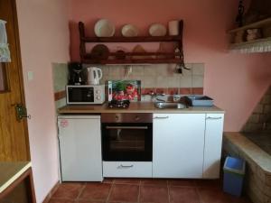 - une petite cuisine avec des placards blancs et un four micro-ondes dans l'établissement Holiday Home Maria, à Pazin