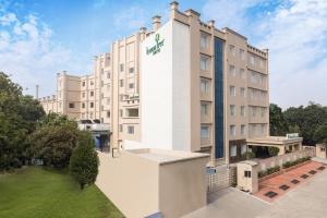 eine Aussicht auf das Hotel mit grünem Rasen in der Unterkunft Lemon Tree Hotel, Aligarh in Aligarh