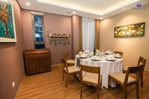 a dining room with a white table and chairs at Purple Lotus Hotel in Hải Dương