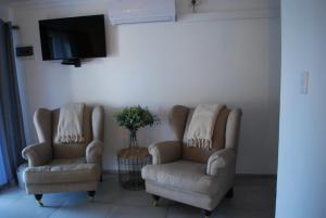 two chairs and a tv in a living room at Vaal De Vue Guesthouse in Christiana