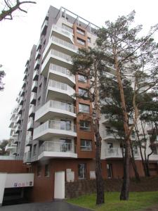 a tall apartment building with trees in front of it at Apartment Antonio in Gdańsk