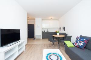 a living room with a couch and a tv and a table at Apartment Antonio in Gdańsk