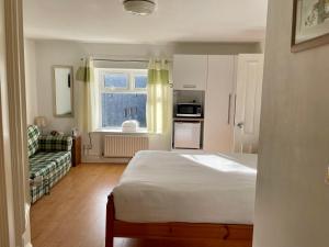una camera da letto con un letto, un divano e una finestra di An Stór Townhouse a Midleton