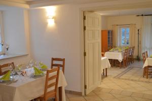 a dining room with white tables and chairs and a dining room with tablesktop at Landhaus Gräfendhron in Gräfendhron