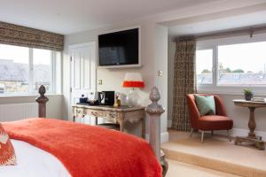 um quarto com uma cama, uma secretária e uma televisão em The Whittling House em Alnmouth