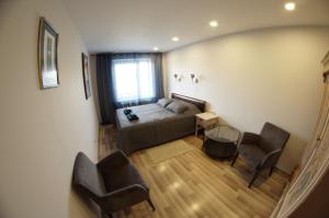 a living room with a bed and two chairs at Jūrkalnes apartamenti in Jūrkalne