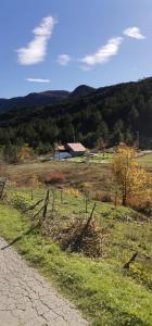 Ein Zaun auf einem Feld mit einer Scheune im Hintergrund in der Unterkunft Trebinje - Lastva - Vikendica Vukovic- in Trebinje