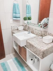 Baño blanco con lavabo y espejo en Pipa Paradise Top 1, en Pipa
