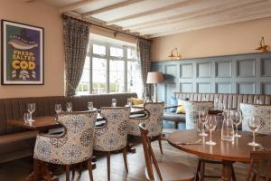 a restaurant with tables and chairs and a couch at The Whittling House in Alnmouth