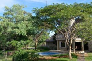 une maison avec une piscine et des arbres dans l'établissement Zebula Golf Estate and Spa - Private Rentals, à Mabula
