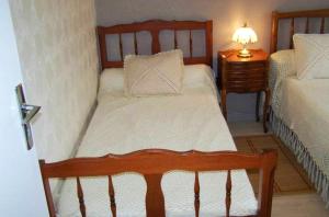 um pequeno quarto com uma cama e uma mesa de cabeceira em Maison de 2 chambres avec jardin clos et wifi a Marcillac la Croisille em Marcillac-la-Croisille
