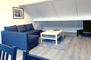 a living room with a blue couch and a table at One bedroom appartement with city view and wifi at Waterloo in Waterloo