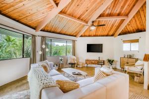a living room with white furniture and a wooden ceiling at Kona Paradise in Kailua-Kona