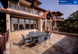 a patio with a table and chairs in front of a house at 7 Yellow Wood Drive, Zimbali Coastal Estate in Ballito