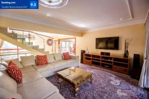 a living room with a couch and a tv at 7 Yellow Wood Drive, Zimbali Coastal Estate in Ballito