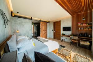 a bedroom with a large white bed and a desk at The Cabin Beach Resort in Haad Rin