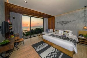 a bedroom with a bed and a view of the ocean at The Cabin Beach Resort in Haad Rin +37 photos