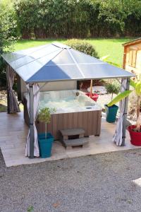 een hot tub met een overdekte patio bij Maison de 3 chambres avec spa jardin clos et wifi a Sains in Sains