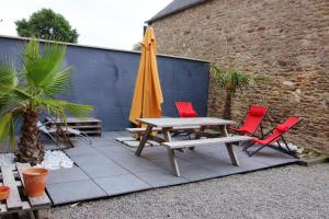 een patio met een tafel en een gele parasol en stoelen bij Maison de 3 chambres avec spa jardin clos et wifi a Sains in Sains