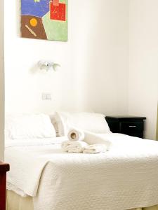 Una cama blanca con un montón de toallas. en Hotel Artico en Mar del Plata