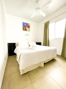 una camera con un letto bianco e una finestra di Hotel Artico a Mar del Plata