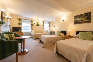 a hotel room with two beds and a living room at Swan Hotel in Wotton under Edge