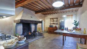 a kitchen with a large fireplace in a room at GERMAGNANA 12&2, Emma Villas in San Miniato