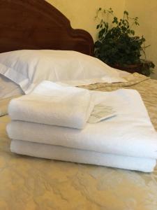 a stack of white towels sitting on a bed at Апартаменти готельного типу in Lviv